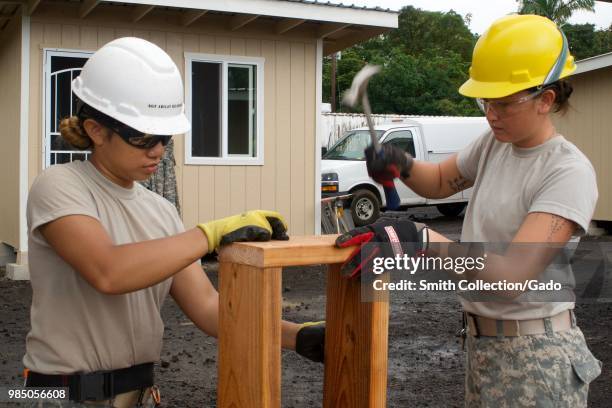 Photograph of electrician Sergeant Kilohana Abilay and plumber Army Specialist Ka-sandra Ragasa working on repairs to a micro-shelter in Pahoa,...