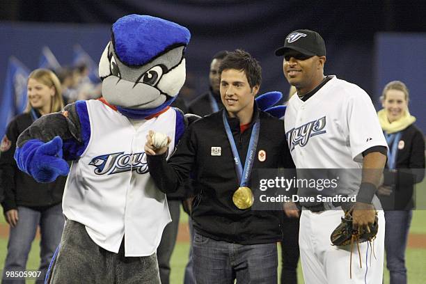Canadian Olympic goal medalist Alex Bilodeau throws the ceremonial pitch to Vernon Wells of the Toronto Blue Jays prior to facing the Chicago White...