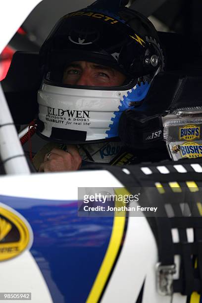 Marcos Ambrose, driver of the Scott Branded Products / Kingsford Toyota, sits in his car during qualifying for the NASCAR Sprint Cup Series Samsung...