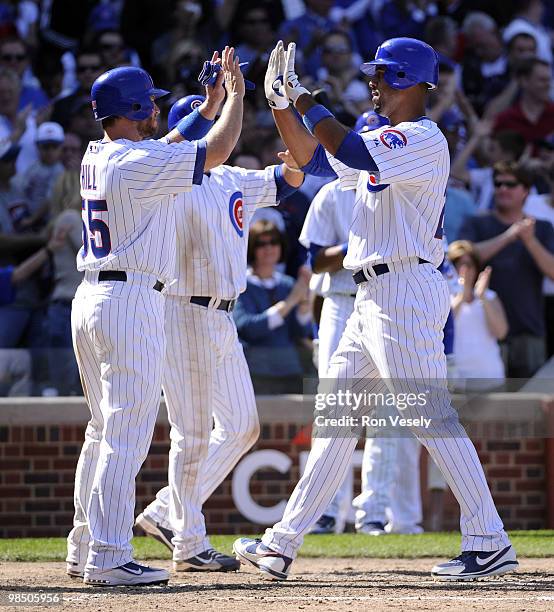 Derrek Lee is greeted at home plate by Koyie Hill of the Chicago Cubs after Lee hit a three run home run in the seventh inning against the Houston...