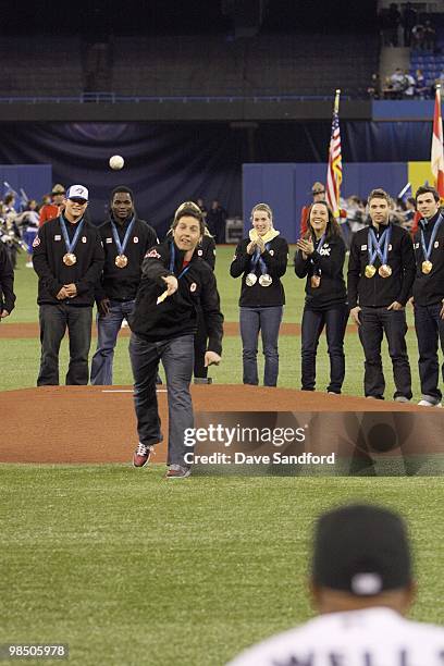 Canadian Olympic goal medalist Alex Bilodeau throws the ceremonial pitch to Vernon Wells of the Toronto Blue Jays prior to facing the Chicago White...