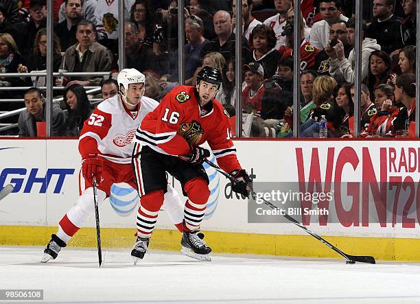 Andrew Ladd of the Chicago Blackhawks looks to pass the puck as Jonathan Ericsson of the Detroit Red Wings watches from behind on April 11, 2010 at...