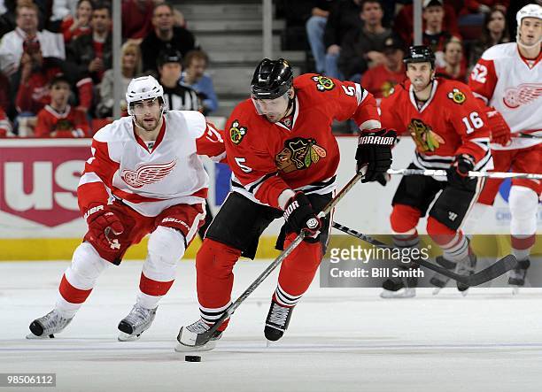 Brent Sopel of the Chicago Blackhawks takes the puck up the ice as Patrick Eaves of the Detroit Red Wings follows behind on April 11, 2010 at the...