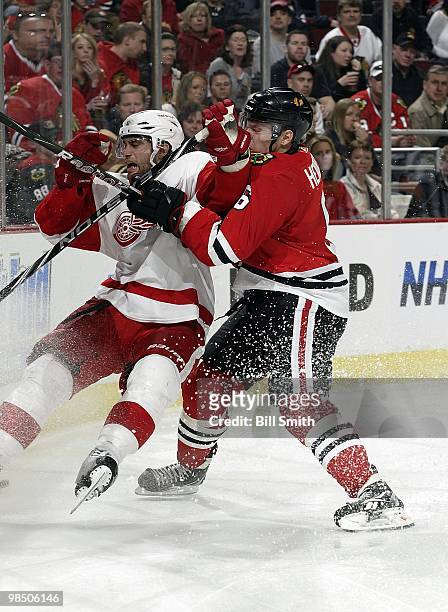 Jordan Hendry of the Chicago Blackhawks pushes Patrick Eaves of the Detroit Red Wings on April 11, 2010 at the United Center in Chicago, Illinois.