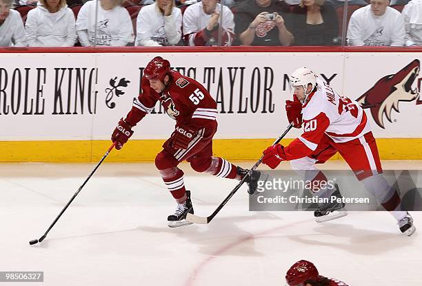 Ed Jovanovski of the Phoenix Coyotes handles the puck under pressure from Drew Miller of the Detroit Red Wings in Game One of the Western Conference...
