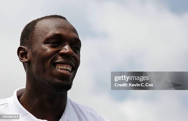 Usain Bolt tees up a golf ball as he drives it into the Caribbean Sea during the quarterfinal matches of The Mojo 6 Jamaica LPGA Invitational at...