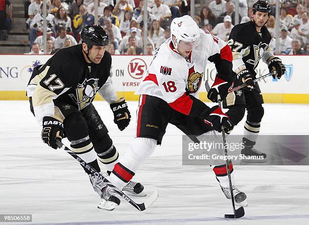 Jesse Winchester of the Ottawa Senators moves the puck in front of Mike Rupp and Craig Adams of the Pittsburgh Penguins in Game Two of the Eastern...