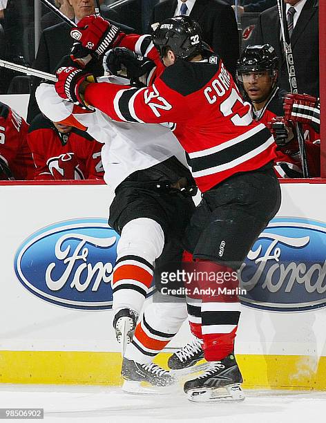 Ian Laperriere of the Philadelphia Flyers is checked high and hard by Matthew Corrente of the New Jersey Devils in Game Two of the Eastern Conference...