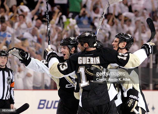 Kris Letang of the Pittsburgh Penguins celebrates his third period goal with Bill Guerin and Mark Eaton against the Ottawa Senators in Game Two of...