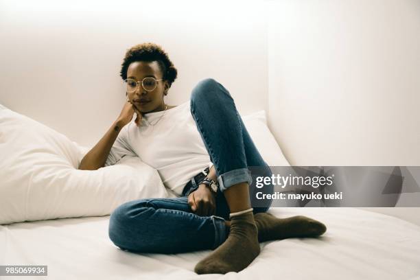 young woman who is relaxed on a bed - ファッション stock pictures, royalty-free photos & images