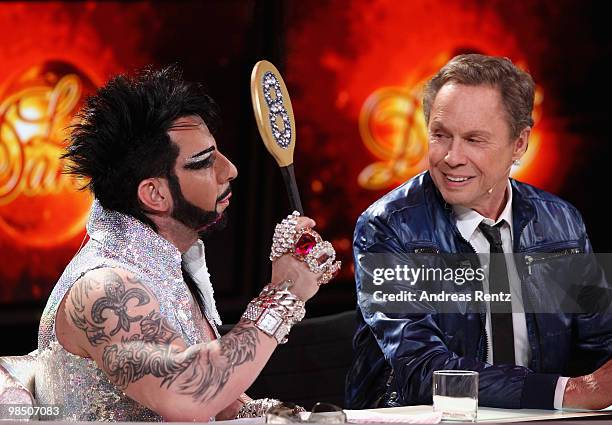 Jury member Harald Gloeoeckler holds up a score card as Peter Kraus smiles during the 'Let's Dance' TV show at Studios Adlershof on April 16, 2010 in...