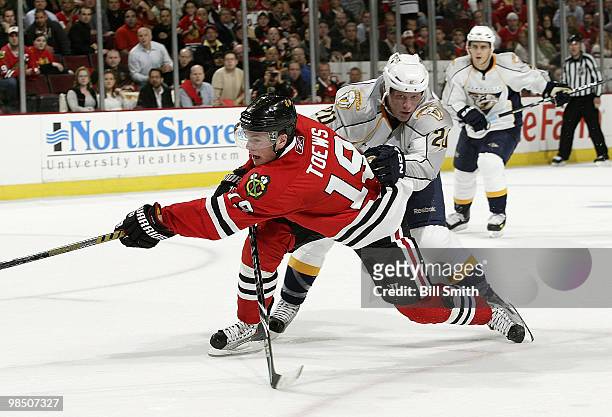 Jonathan Toews of the Chicago Blackhawks tries to deflect the puck as Ryan Suter of the Nashville Predators keeps his eye on the puck from behind, at...
