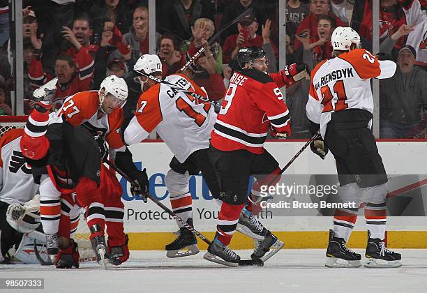 Dainius Zubrus of the New Jersey Devils is flipped in front of the net after scoring the game winning goal as teammate Zach Parise celebrates in...