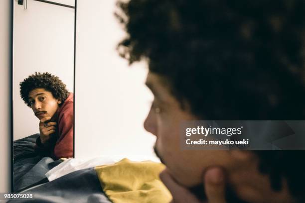 young man who is relaxed on a bed - ファッション stock pictures, royalty-free photos & images