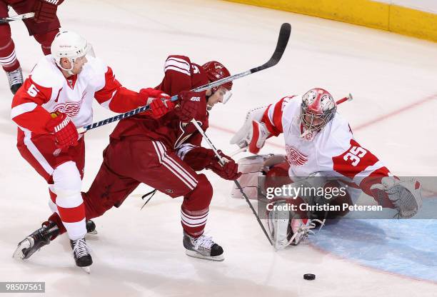 Goaltender Jimmy Howard of the Detroit Red Wings dives to make a save on Matthew Lombardi of the Phoenix Coyotes as Nicklas Lidstrom defends in the...