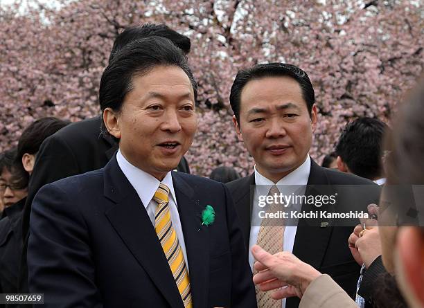 Japanese Prime Minister Yukio Hatoyama shakes hands with guests during the annual government cherry blossom viewing party at Shinjuku Gyoen park on...