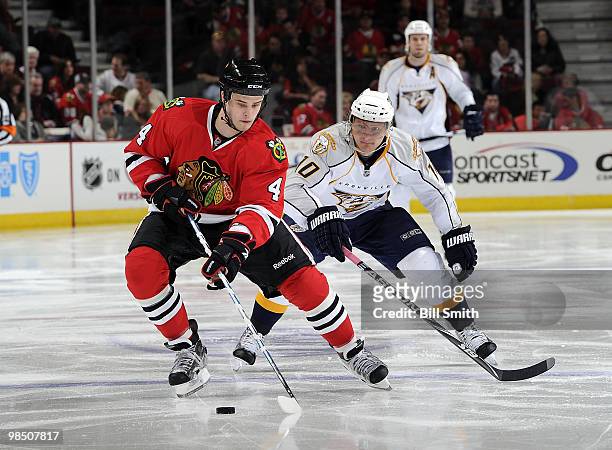 Niklas Hjalmarsson of the Chicago Blackhawks approaches the puck as Martin Erat of the Nashville Predators skates in from behind at Game One of the...