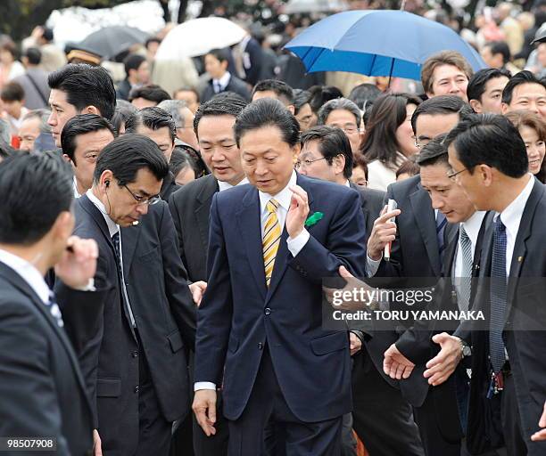 Surrounded by security policemen, Japanese Prime Minister Yukio Hatoyama appears at a garden party to admire cherry blossoms hosted by Hatoyama in...