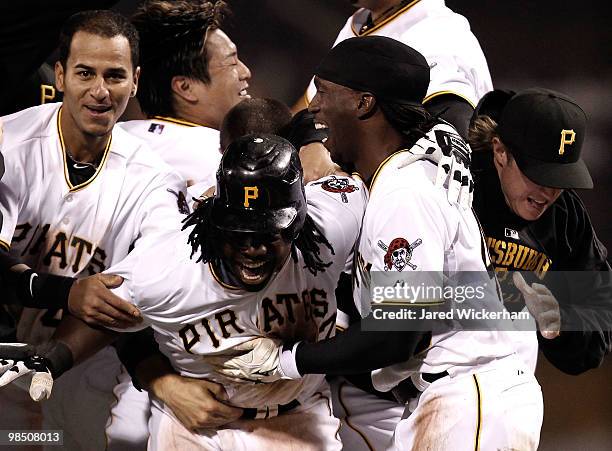 Lastings Milledge of the Pittsburgh Pirates is mobbed by teammates after driving in the game winning run to beat the Cincinnati Reds during the game...