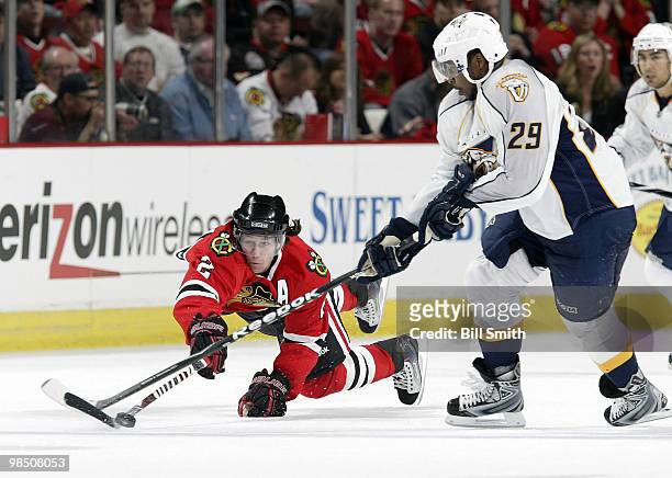 Duncan Keith of the Chicago Blackhawks leaps toward the puck as Joel Ward of the Nashville Predators reaches across, at Game One of the Western...