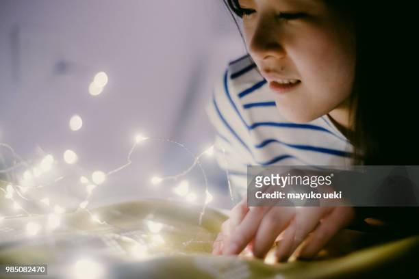 junge frau mit einer menge von kleinen lichtern mit ihren händen - 蛍 stock-fotos und bilder