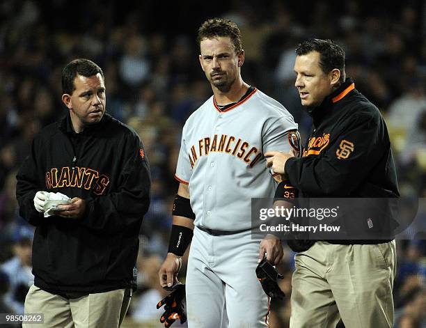 Aaron Rowand of the San Francisco Giants is helped off the field by trainers after being hit in the head by a pitch from Vicente Padilla of the Los...