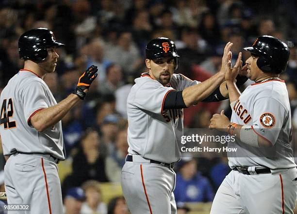 Bengie Molina of the San Francisco Giants celebrates his run with Mark DeRosa and Todd Wellemeyer to trail the Los Angeles Dodgers 7-2 during the...