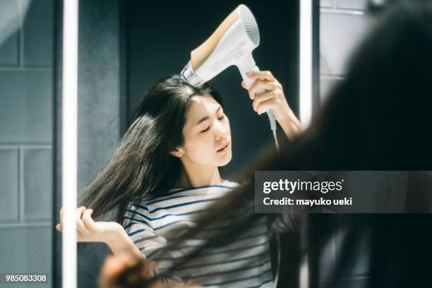 young woman who dries hair with a dryer - ファッション stock pictures, royalty-free photos & images