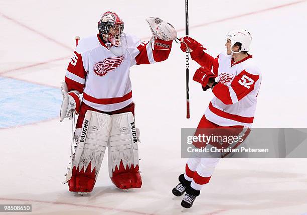 Goaltender Jimmy Howard of the Detroit Red Wings is congratulated by teammate Jonathan Ericssonn after defeating the Phoenix Coyotes in Game Two of...