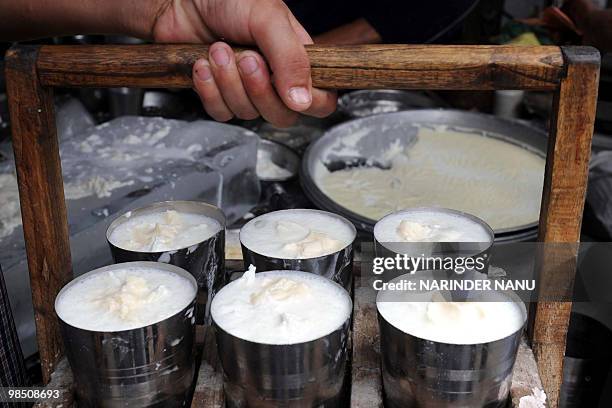 An Indian waiter serves glasses of lassi at The Punjabi Lassi Stall in Amritsar on April 16, 2010. Lassi is made by blending yoghurt with water, milk...