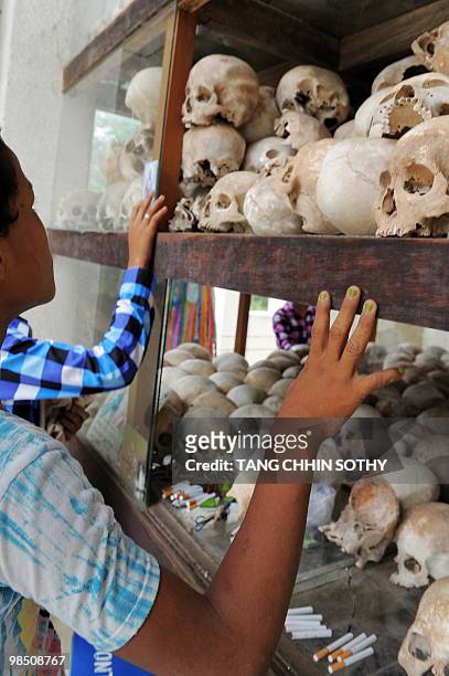 Cambodian boy looks at skulls displayed at the Choeung Ek killing fields memorial in Phnom Penh on April 17, 2010. Cambodia marked the 35th...