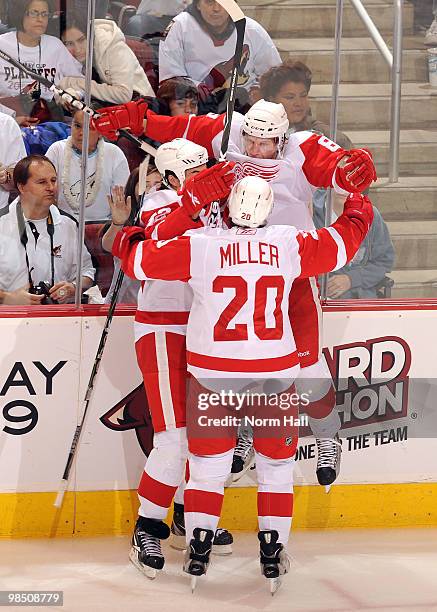 Justin Abdelkader of the Detroit Red Wings celebrates with teammates Drew Miller and Mattias Ritola after scoring against the Phoenix Coyotes in Game...