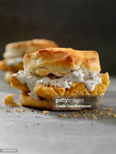 fried chicken sandwich with sausage gravy on a biscuit - buttermilk biscuit stock pictures, royalty-free photos & images