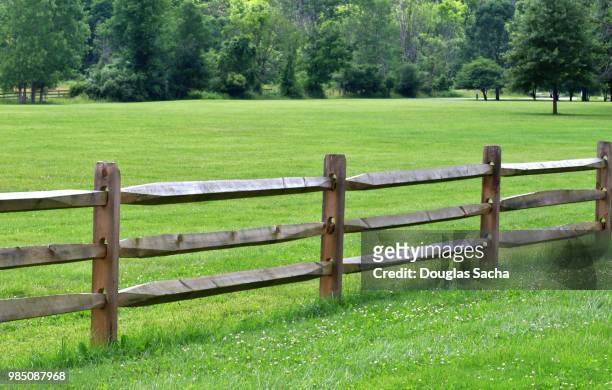 split rail fence along a grass field - sprossenzaun stock-fotos und bilder