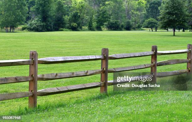 split rail fence along a grass field - cercado - fotografias e filmes do acervo