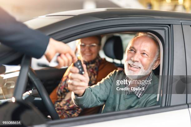feliz pareja senior, comprar un automóvil. - car ownership fotografías e imágenes de stock