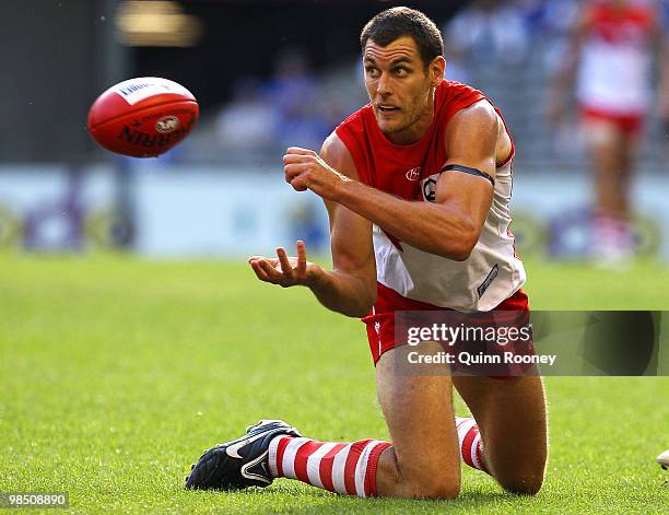 Mark Seaby of the Swans handballs during the round four AFL match between the North Melbourne Kangaroos and the Sydney Swans at Etihad Stadium on...