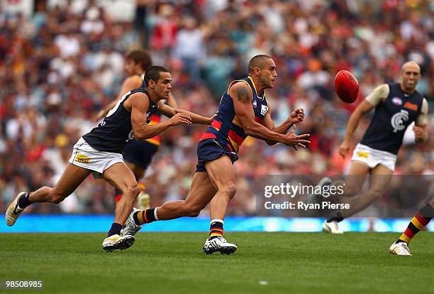 Andrew McLeod of the Crows handballs clear of Jeff Garlett of the Blues during the round four AFL match between the Adelaide Crows and the Carlton...