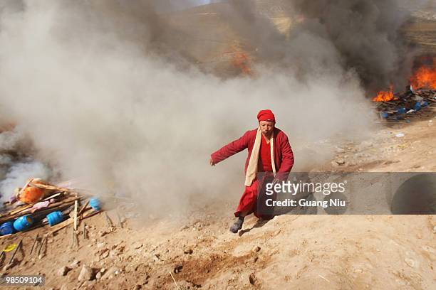 Tibrtan monk runs away after carrying a dead body to a fire funeral following a strong earthquake on Jiegu toweship of China's Qinghai province just...