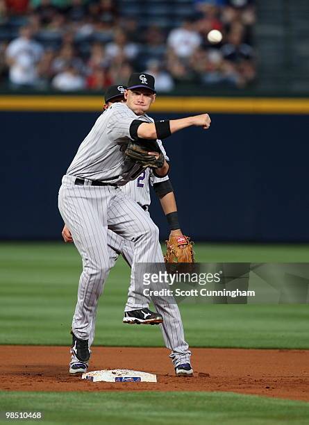 Clint Barmes of the Colorado Rockies turns a double play against the Atlanta Braves at Turner Field on April 16, 2010 in Atlanta, Georgia. The Braves...
