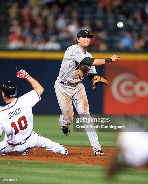 Troy Tulowitzki of the Colorado Rockies turns a double play against Chipper Jones of the Atlanta Braves at Turner Field on April 16, 2010 in Atlanta,...