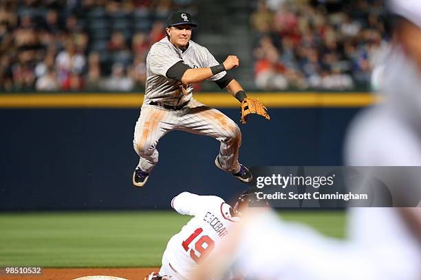 Troy Tulowitzki of the Colorado Rockies turns a double play against Yunel Escobar of the Atlanta Braves at Turner Field on April 16, 2010 in Atlanta,...