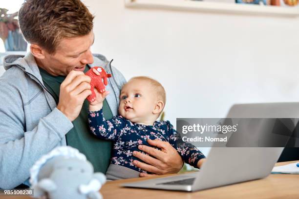 vader en zoon spelen met olifant speelgoed aan tafel - elephant at home stockfoto's en -beelden