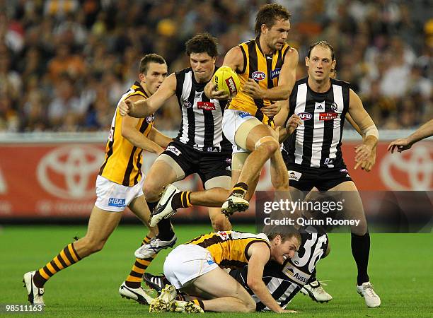 Luke Hodge of the Hawks jumps over a pack of players during the round four AFL match between the Collingwood Magpies and the Hawthorn Hawks at...