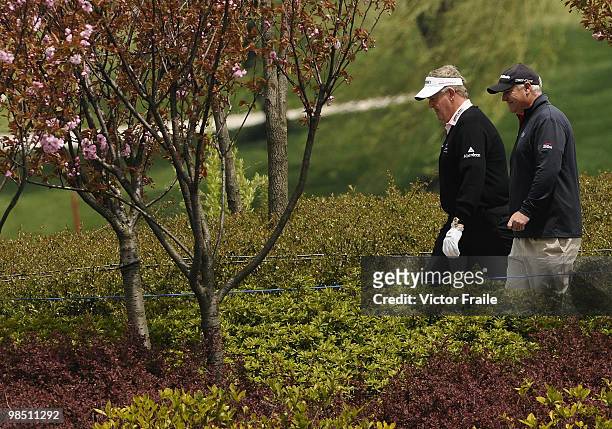Colin Montgomerie of Scotland and Stephen Dood of Wales walk on the 2nd hole during the Round Three of the Volvo China Open on April 17, 2010 in...