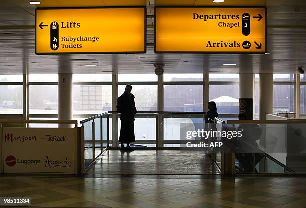 Woman looks out onto the tarmac at London Gatwick Airport in Hurley, West Sussex, on April 17, 2010. Britain has extended a ban on most flights in...