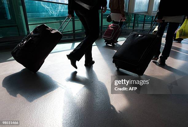 Passengers walk in London Gatwick Airport in Hurley, West Sussex on April 17, 2010. Britain has extended a ban on most flights in its airspace until...