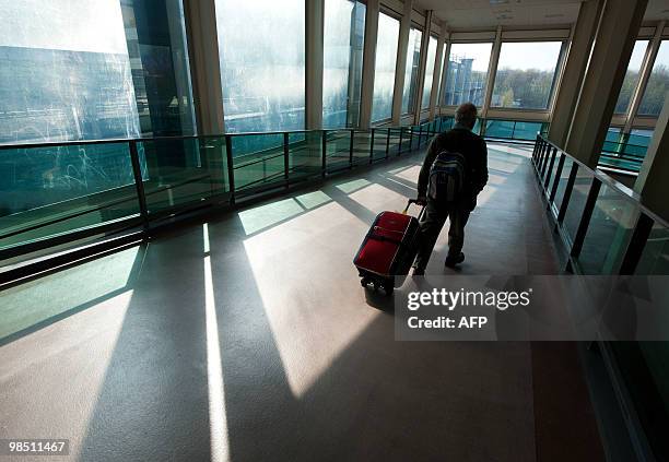 Passenger walks in London Gatwick Airport in Hurley, West Sussex on April 17, 2010. Britain has extended a ban on most flights in its airspace until...