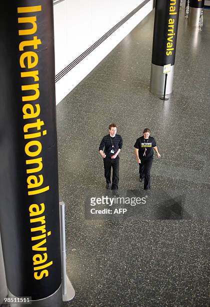 Man and woman walk through an otherwise deserted international arrivals area at London Gatwick Airport in Hurley, West Sussex on April 17, 2010....