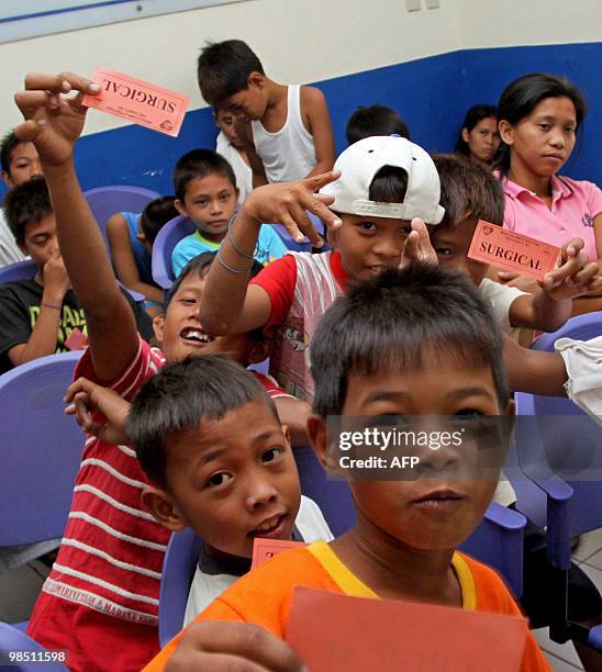 Young boys show their surgical admission slips as they wait their turn during a mass circumcision program at a municipal hospital in the town of...